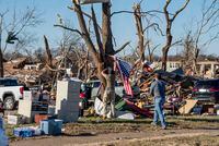 An American flag is affixed to a tree in Mayfield, Ky., Dec. 12, 2021, after an outbreak of tornadoes on Friday night, including one that traveled more than 220 catastrophic miles, left a deep scar of devastation. (