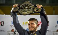 (FILES) In this file photo taken on October 8, 2018 UFC lightweight champion Khabib Nurmagomedov of Russia raises his champions belt upon the arrival in Makhachkala. - World lightweight mixed martial arts (MMA) champion Khabib Nurmagomedov, unbeaten in 29 fights, has announced on October 24, 2020 to everyone's surprise that he retires at 32 to keep a promise made to his mother. (Photo by Vasily MAXIMOV / AFP) (Photo by VASILY MAXIMOV/AFP via Getty Images)