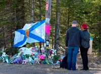 A couple pays their respects at a makeshift memorial in Portapique, N.S., on April 22, 2020.