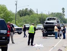 Local law enforcement and FBI agents investigate a deadly scene after a driver of a Range Rover struck a group of migrants, Sunday, May 7, 2023, along North Minnesota Avenue across from Ozanam Center, a migrant and homeless shelter in Brownsville, Texas. (Miguel Roberts/The Brownsville Herald via AP)