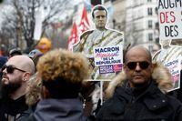 FILE PHOTO: A demonstrator holds a sign with an image of French President Emmanuel Macron at a protest against the government's pension reform plan in Paris, France, March 11, 2023. REUTERS/Benoit Tessier/File Photo