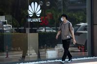 A man wearing a mask to curb the spread of the coronavirus walks past a Huawei store promoting 5G technologies in Beijing on Wednesday, July 15, 2020. China's government accused Britain on Wednesday of colluding with Washington to hurt Chinese companies after tech giant Huawei was blocked from working on a next-generation mobile phone network. (AP Photo/Ng Han Guan)