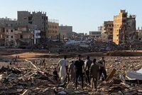 People walk through debris after a powerful storm and heavy rainfall hit Libya, in Derna, Libya, September 12, 2023 in this still image from video obtained from social media.