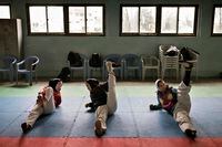 FILE Ñ Zakia Khudadadi, left, stretches before training at the Afghan National Taekwondo Federation gym in Kabul on March 16, 2016. Amid the fear and turmoil in Afghanistan, the countryÕs two Paralympic athletes have been prevented from traveling to the Tokyo 2020 Paralympic Games. (Adam Ferguson/The New York Times)