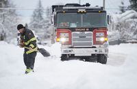 A firefighter shovels a sidewalk in North Vancouver, B.C., Jan. 15, 2020.