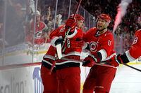 Carolina Hurricanes' Jesper Fast (71) celebrates with teammates Brent Burns, and Jordan Staal (11) his game winning overtime goal against New York Islanders in Game 2 of an NHL hockey Stanley Cup first-round playoff series in Raleigh, N.C., Wednesday, April 19, 2023. (AP Photo/Karl B DeBlaker)