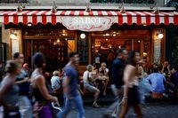 Tourists walk past a restaurant at the Butte Montmartre in Paris, France, August 7, 2022. REUTERS/Sarah Meyssonnier