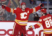 Calgary Flames left wing Matthew Tkachuk (19) celebrates his 40th goal and his 100th point of the season with teammate left wing Andrew Mangiapane (88) during second period NHL hockey action against the Dallas Stars in Calgary on Thursday April 21, 2022. THE CANADIAN PRESS/Larry MacDougal