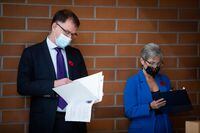 British Columbia Health Minister Adrian Dix, left, and Finance Minister Selina Robinson, who is a cancer survivor, wait to speak during the official opening of the Canadian Cancer Society Centre for Cancer Prevention and Support, in Vancouver, on Wednesday, November 10, 2021. THE CANADIAN PRESS/Darryl Dyck