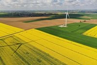 FILE PHOTO: An aerial view shows a power-generating windmill turbine in the middle of rapeseed fields, in Saint-Hilaire-lez-Cambrai, France, May 7, 2021. Picture taken with a drone. REUTERS/Pascal Rossignol/File Photo
