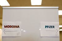 FILE PHOTO: Signs and age groups are shown for the Pfizer and Moderna vaccines at a vaccination center as California opens up vaccine eligibility to any residents 16 years and older during the outbreak of coronavirus disease (COVID-19) in Chula Vista, California, U.S., April 15, 2021.  REUTERS/Mike Blake/File Photo