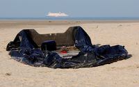 FILE PHOTO: A damaged inflatable dinghy lies on the beach in Gravelines, one of the beaches used by migrants to leave by small dinghies the coast of northern France to cross the English Channel in an attempt to reach Britain, near Calais, France, December 14, 2022.  REUTERS/Pascal Rossignol/File Photo