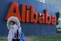 A woman wearing a face mask walks by the offices of Chinese e-commerce firm Alibaba in Beijing on Dec. 13, 2021. A former employee of Chinese e-commerce giant Alibaba says human resources and upper management wouldn’t deal with her accusation of sexual assault. So she went into the busy cafeteria at the headquarters of the Chinese e-commerce giant and screamed out her plight. Now she is paying the price. The company fired her. (AP Photo/Andy Wong)