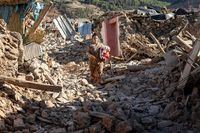 A woman walks past destroyed houses after an earthquake in the mountain village of Tafeghaghte, southwest of the city of Marrakesh, on September 9, 2023. Morocco's deadliest earthquake in decades has killed more than 1,300 people, authorities said on September 9, as troops and emergency services scrambled to reach remote mountain villages where casualties are still feared trapped. (Photo by FADEL SENNA / AFP) (Photo by FADEL SENNA/AFP via Getty Images)