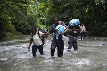 FILE - Haitian migrants wade through a river as they cross the Darien Gap, from Colombia into Panama, hoping to reach the U.S., Oct. 15, 2022. The United States, Panama and Colombia announced Tuesday, April 11, 2023, that they will launch a 60-day campaign aimed at halting illegal migration through the treacherous Darien Gap, where the flow of migrants has multiplied this year. (AP Photo/Fernando Vergara, File)