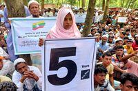 FILE PHOTO: Rohingya refugees hold placards as they gather at the Kutupalong Refugee Camp to mark the fifth anniversary of their fleeing from neighbouring Myanmar to escape a military crackdown in 2017, in Cox's Bazar, Bangladesh, August 25, 2022. REUTERS/Rafiqur Rahman/File Photo